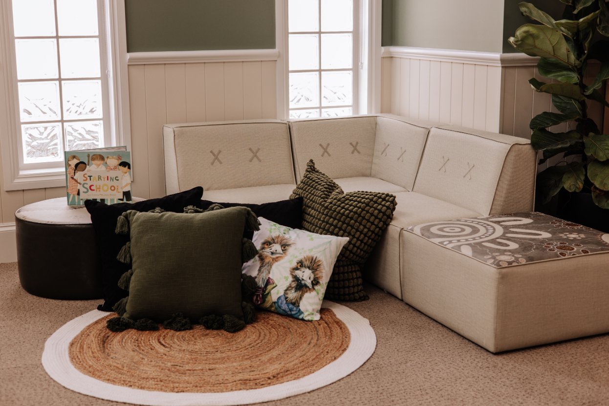 A styled Florence corner sofa with cushions and patterned ottoman foot stools on a woven rug