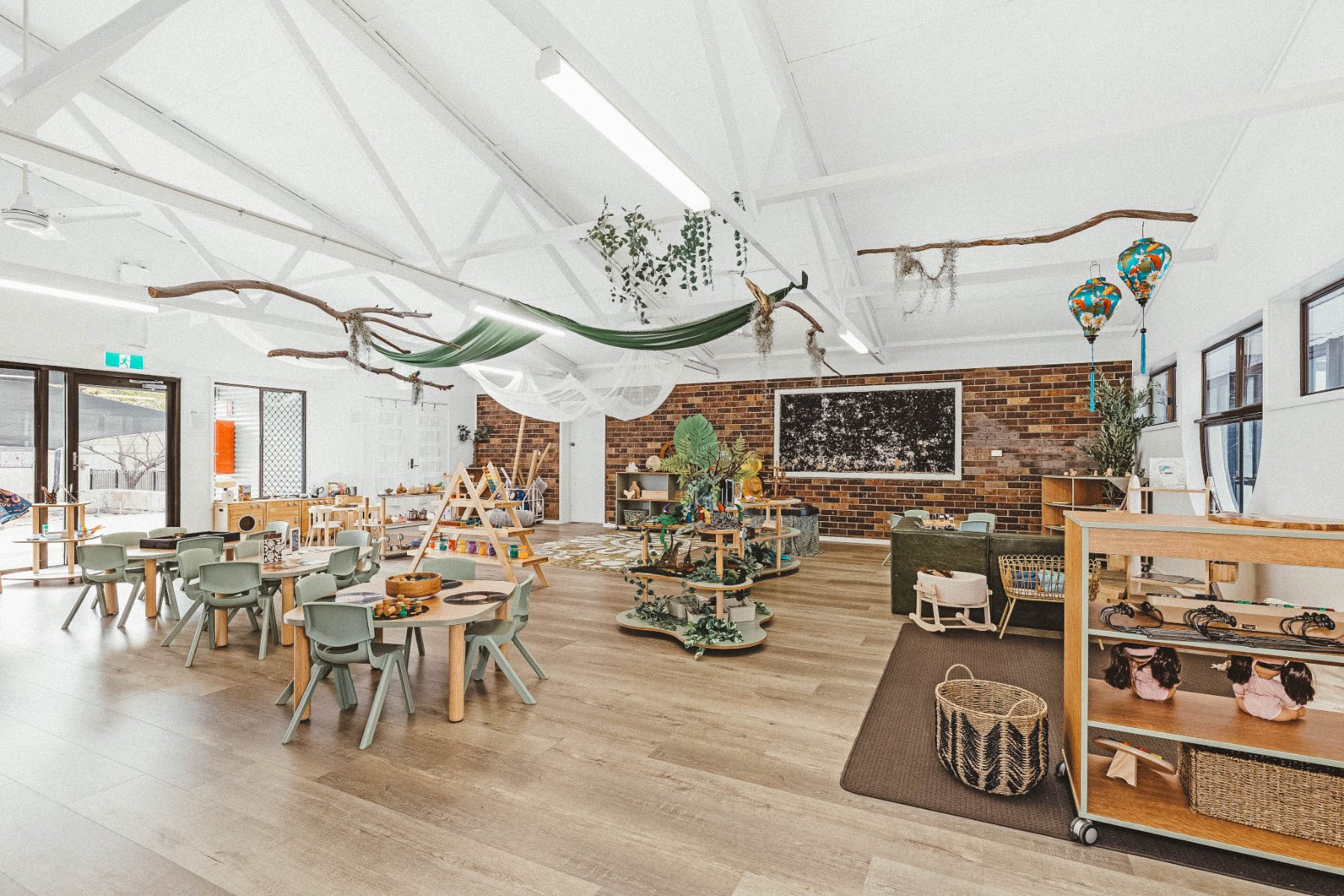A styled Step4 early learning room with sage seating and hanging greenery