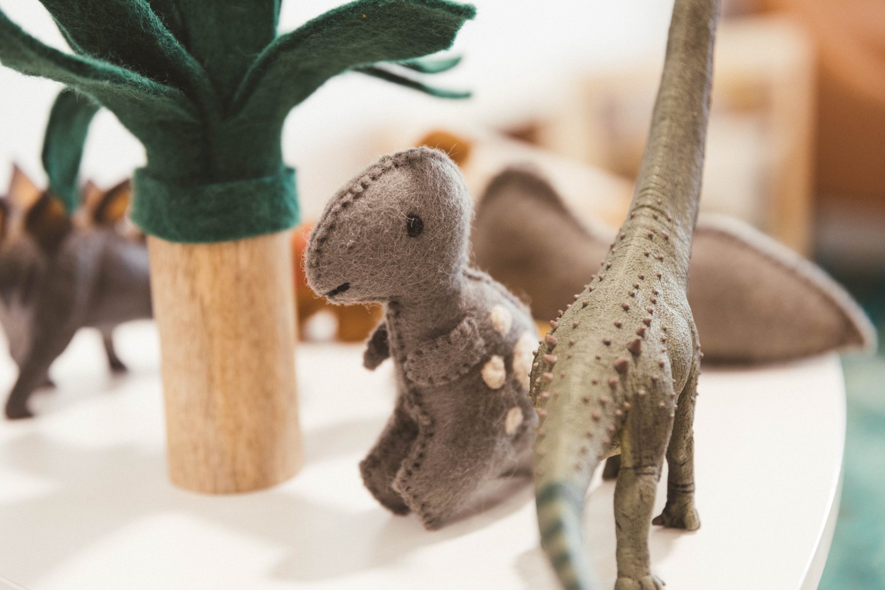 Felt and figurine dinosaurs on a play table