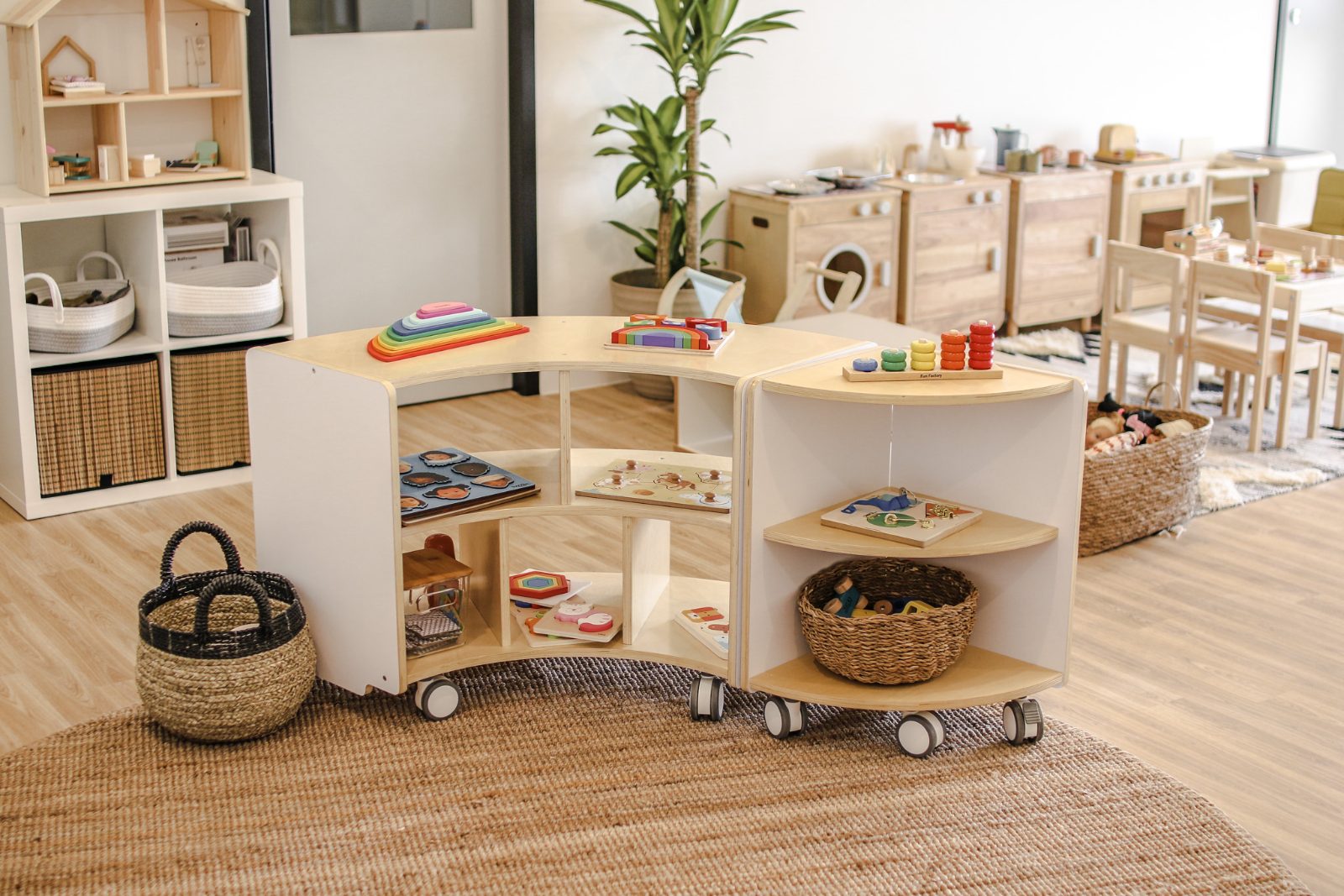 A studio room set up with mobile timber shelving, baskets and learning resources ready for the day