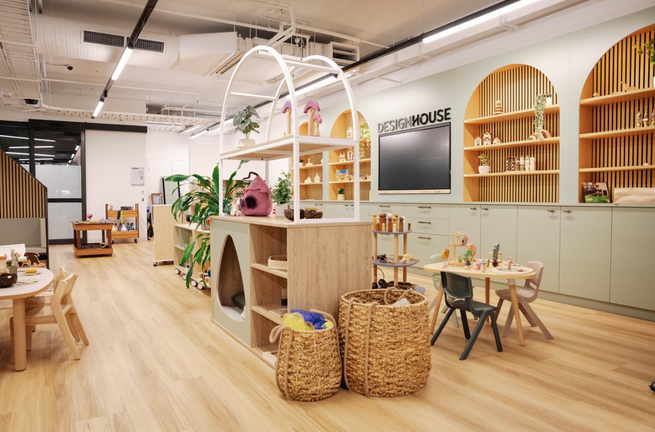 The Step4 showroom with arched timber display shelving, curved resource tables and a styled play unit