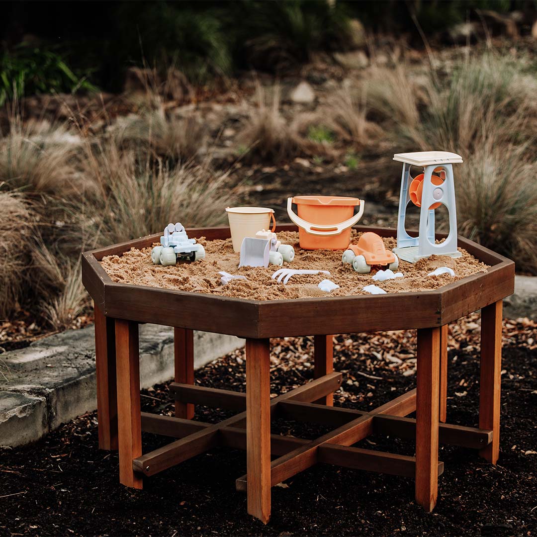 A Willow octagonal sand play table filled with sand and play vehicles